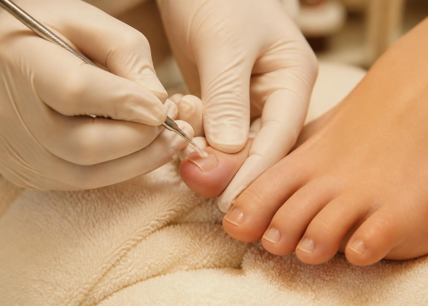 Close-up of careful professional toenail treatment